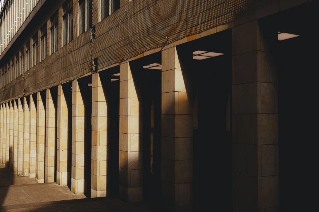 Rangée de colonnes claires éclairées par la lumière du jour.