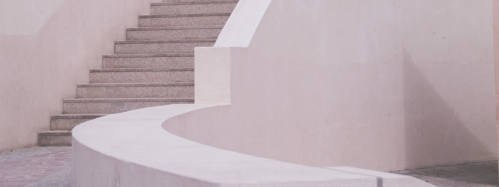 Escalier courbe aux tons clairs dans une architecture minimaliste.