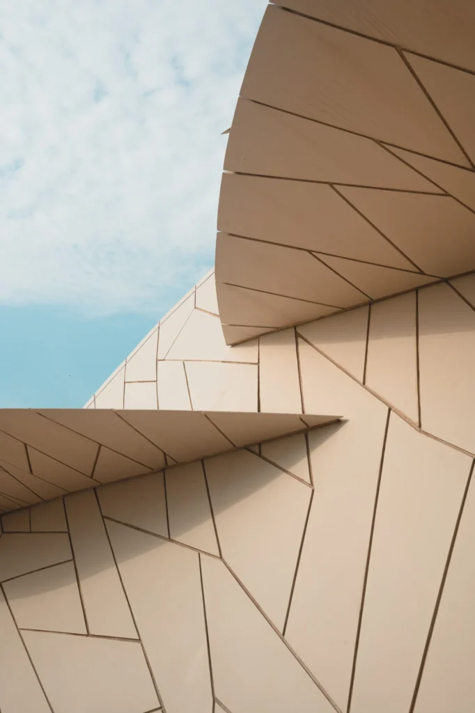 Façade beige aux lignes géométriques répétées.
