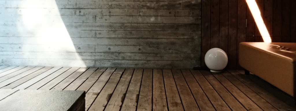 Mur de béton et plancher de bois dans la lumière du soleil